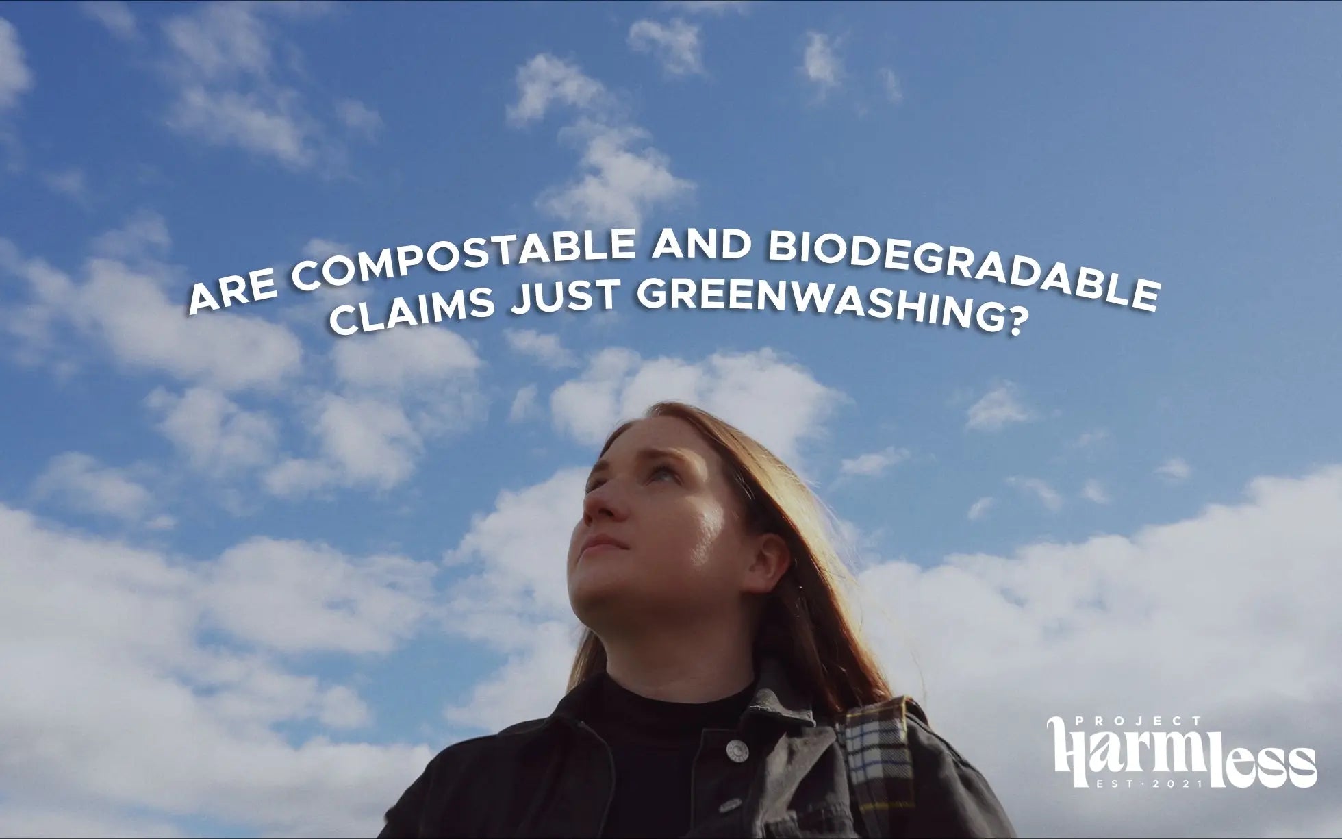 Laura Young looks thoughtfully up at a blue sky with scattered clouds. Above her head, the text reads, ‘Are Compostable and Biodegradable Claims Just Greenwashing?’ In the bottom right corner, the Project Harmless logo is displayed.