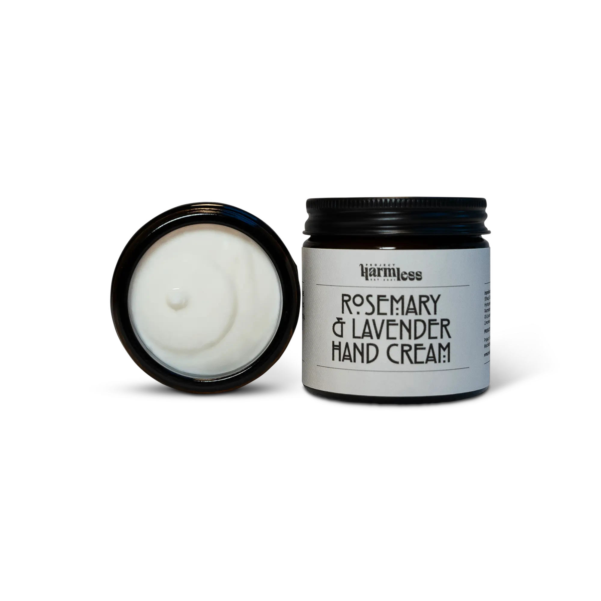 Rosemary & Lavender Hand Cream by Project Harmless, displayed next to an open premium black glass jar with an aluminum cap and a label made from premium textile. Showcasing the rich texture of the cream, crafted in small batches with organic essential oils and Shea Butter.