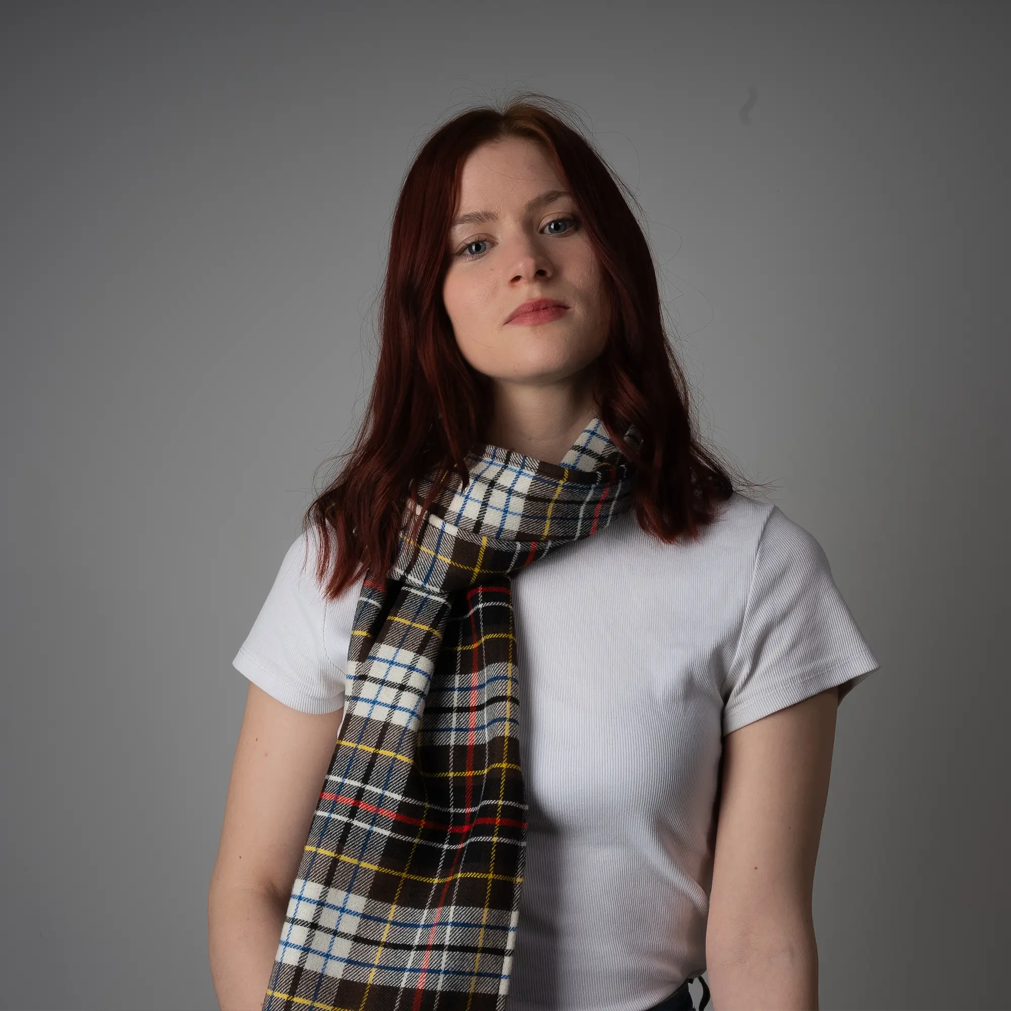 Woman wearing Harmless Atelier 1970 Edinburgh Commonwealth Games pure wool tartan scarf handmade in the Scottish Borders by Project Harmless