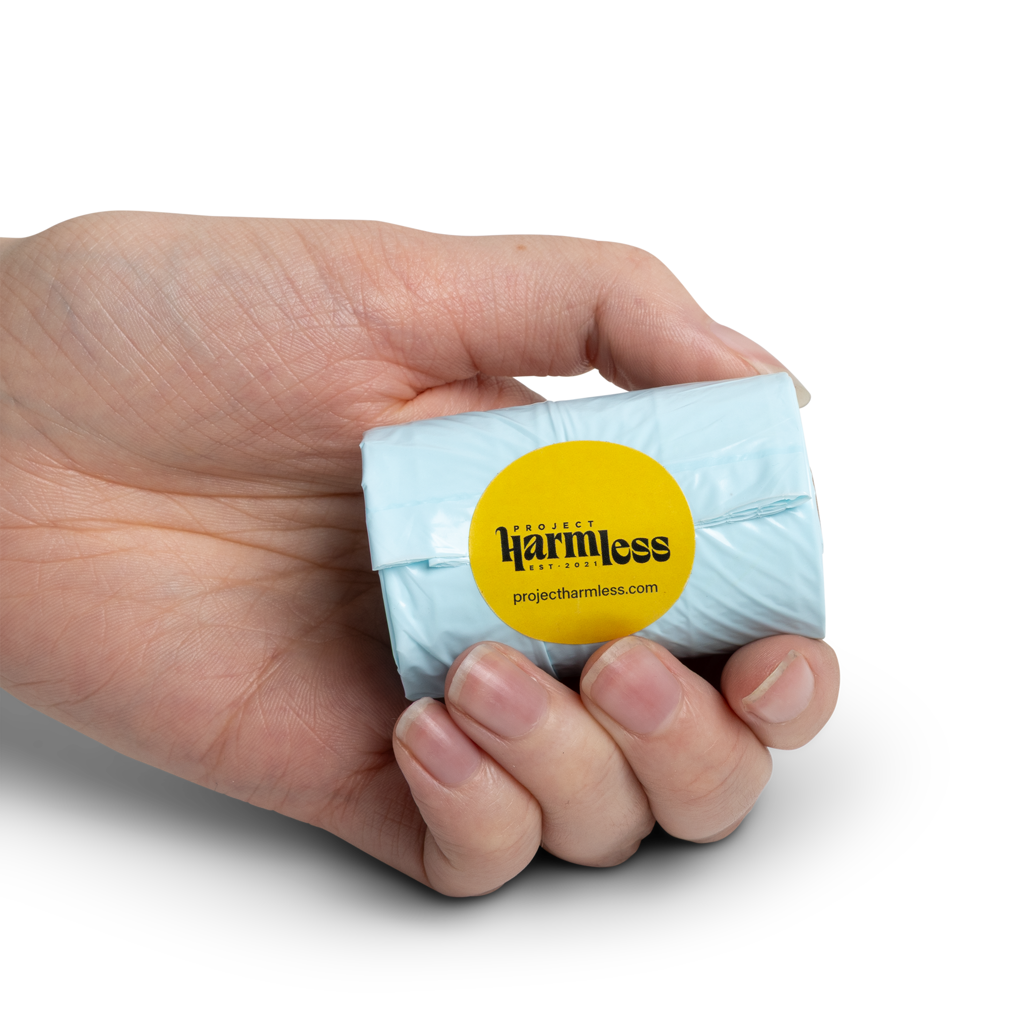 Hand holding a single roll of Harmless dissolvable dog poo bags