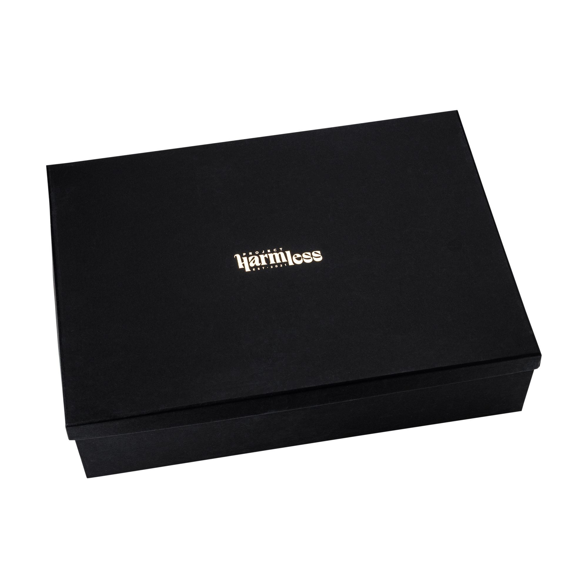 Close-up of the black Project Harmless luxury gift box with gold foil Project Harmless logo, black tissue paper, and blank note card — premium eco packaging for Scottish gifts.