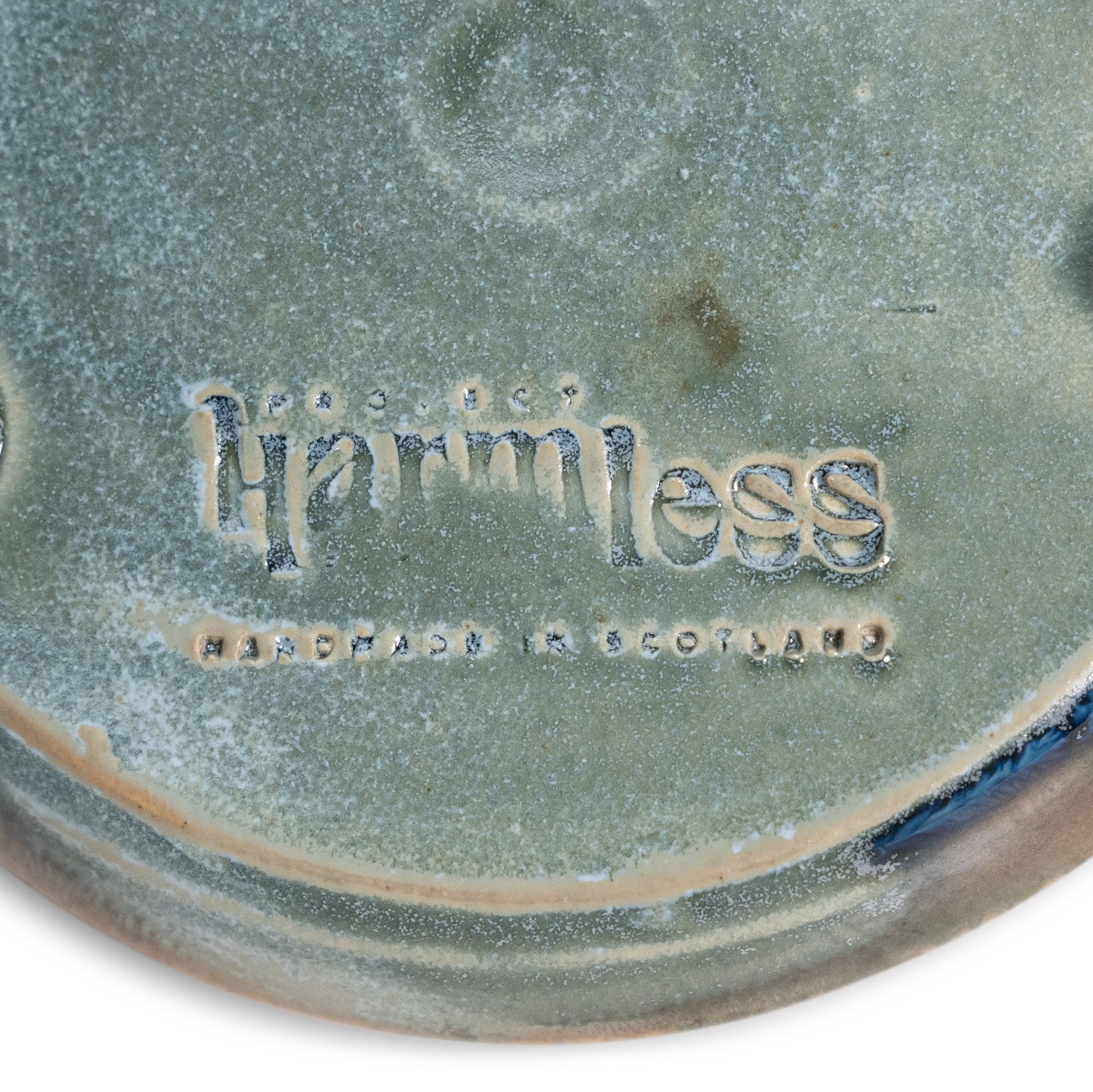 Close up base view of Project Harmless handmade Sea Mist stoneware soap dish, showing hand-thrown detail, a Project Harmless logo, and text "Handmade in Scotland"
